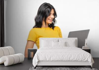 Young smiling confident woman using laptop and looking camera isolated over white Wall mural